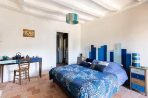 a bedroom with a bed and a desk and a chair at Au Bo Voyage in Tavant