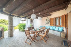 a patio with a table and chairs and a couch at Villa Clelia in Palau