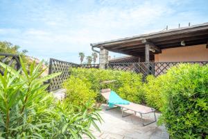 a patio with a chair and some bushes at Villa Clelia in Palau