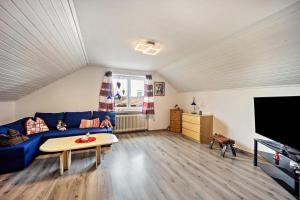 a living room with a blue couch and a tv at Elli in Aulendorf
