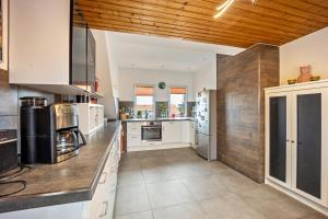 a large kitchen with white appliances and wooden ceilings at Elli in Aulendorf +8 photos