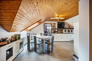 a kitchen with a table and chairs and a wooden ceiling at Elli in Aulendorf