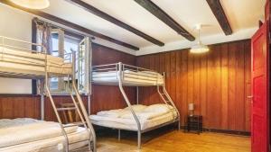 two bunk beds in a room with wooden walls at Das Schneiderhaus in Höchenschwand
