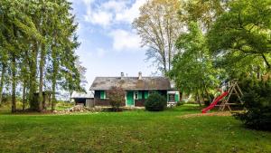 a small house in a field with a playground at Das Schneiderhaus in Höchenschwand