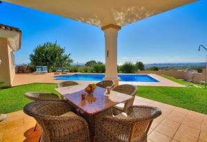 a patio with a table and chairs and a pool at Luxurius Villa with private pool in Mijas
