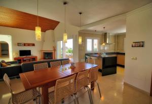 a kitchen and living room with a wooden table and chairs at Luxurius Villa with private pool in Mijas