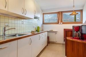 a kitchen with white cabinets and a sink at Haus Rosengarten Apt C in Terlano +19 photos