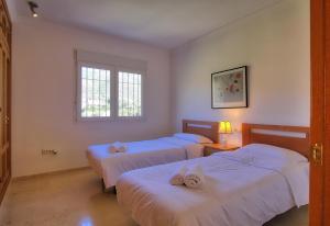 a room with three beds and a window at Luxurius Villa with private pool in Mijas +16 photos