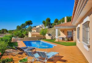 a backyard with a swimming pool and chairs and a house at Luxurius Villa with private pool in Mijas