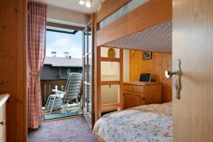 a bedroom with a bed and a desk and a chair at Ferienwohnung Huttenberg in Reit im Winkl