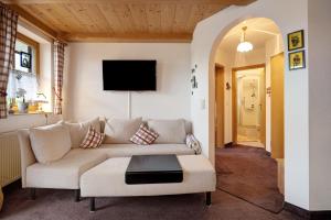 a living room with a couch and a tv at Ferienwohnung Huttenberg in Reit im Winkl