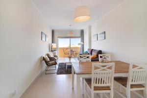 a dining room and living room with a table and chairs at Royal Cabanas Golf 87 in Cabanas de Tavira
