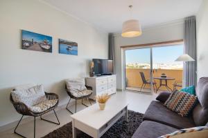 a living room with a couch and chairs and a tv at Royal Cabanas Golf 87 in Cabanas de Tavira