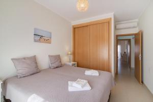 a bedroom with a bed with two towels on it at Royal Cabanas Golf 87 in Cabanas de Tavira +25 photos