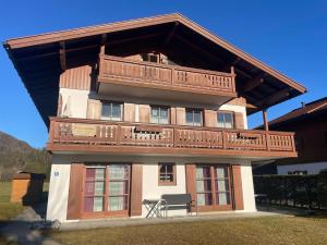 a large house with a balcony on top of it at Ferienwohnung Huttenberg in Reit im Winkl