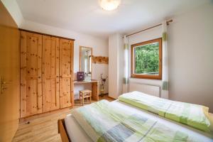 a bedroom with a bed and a window and a desk at Langeshof Fewo Morgensonne in Caines