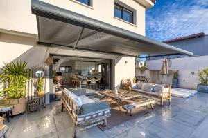 a patio with couches and a table and chairs at Sublime Maison Moderne avec piscine in Mauguio