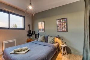 a bedroom with a large bed with blue sheets at Sublime Maison Moderne avec piscine in Mauguio +22 photos