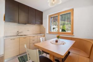 a kitchen with a table and a sink and a window at Innerjerberhof Neiderseit in Lauregno