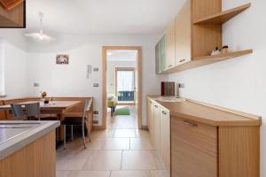 a kitchen with wooden cabinets and a dining table at Innerjerberhof Neiderseit in Lauregno +20 photos