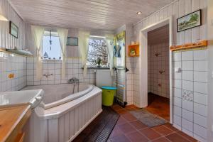 a bathroom with a tub and a shower and a sink at Ferienhaus Busch in Elpersbüttel +23 photos