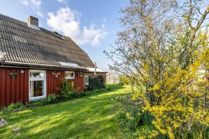 a red house with a yard next to a building at Ferienhaus Busch in Elpersbüttel