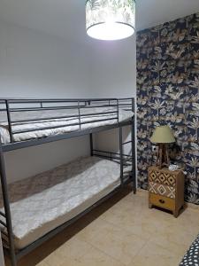 a room with two bunk beds and a lamp at Constance in L'Ampolla