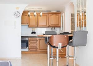 a kitchen with wooden cabinets and a table with chairs at Constance in L'Ampolla