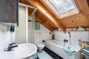 a bathroom with a tub and a toilet and a skylight at Ferienwohnung Breitenberger in Herrsching am Ammersee +28 photos