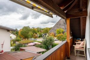 an outdoor balcony with tables and a thatched roof at Ferienwohnung Breitenberger in Herrsching am Ammersee
