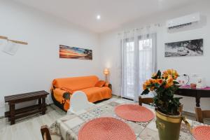 a living room with an orange couch and a table at Casa Vacanza Iris Castelvetrano in Castelvetrano Selinunte