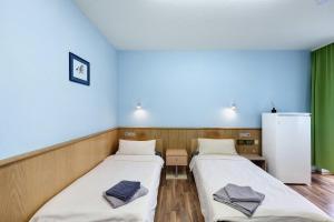 two beds in a room with blue walls at Hotel Neue Krone - Markt Erlbach in Markt Erlbach