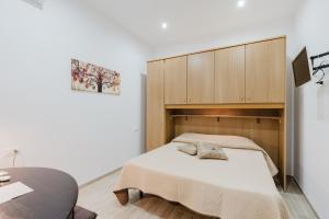 a bedroom with a bed and a wooden cabinet at Casa Vacanza Iris Castelvetrano in Castelvetrano Selinunte