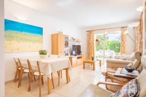 a kitchen and living room with a table and chairs at Apartamento Olot in Pollença