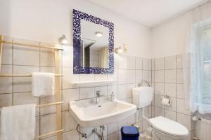a bathroom with a sink and a toilet and a mirror at Haus Annenberg in Monzelfeld +24 photos