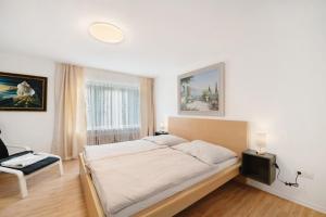 a bedroom with a bed and a chair and a window at Haus Annenberg in Monzelfeld