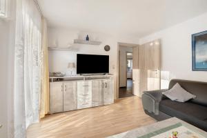 a living room with a couch and a flat screen tv at Haus Annenberg in Monzelfeld