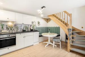 a kitchen with white cabinets and a table and a staircase at Ferienhaus Bernoth in Erfurt