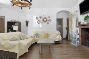 a living room with a white couch and a fireplace at Finca Arroyuelo in Prado del Rey