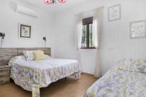 a bedroom with two beds and a window at Finca Arroyuelo in Prado del Rey +22 photos