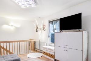 a living room with a tv on top of a white cabinet at Ferienhaus Bernoth in Erfurt