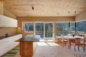 a kitchen with a table and chairs and a large window at Pitschlhof Apt Zirbe in Aldino +20 photos