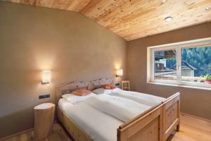 a bedroom with a large bed with a window at Pitschlhof Apt Zirbe in Aldino