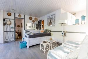 a living room with a bed and a couch at Villa Cap Ferret - Réf 230 in Lège-Cap-Ferret +12 photos