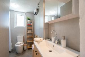 a bathroom with a sink and a toilet at Punda Beach Seaside Retreat in Kampos Paros +22 photos
