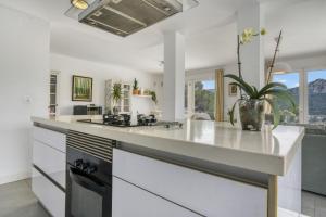 a kitchen with white walls and a large counter top at Villa Sol in Orba