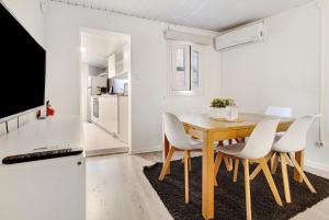 a dining room with a wooden table and white chairs at Prestigegoldresidence 1 - Old Town in Guimarães