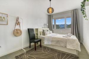 a bedroom with a bed and a chair and a window at Villa Sol in Orba +17 photos