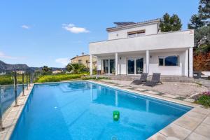a villa with a swimming pool in front of a house at Villa Sol in Orba