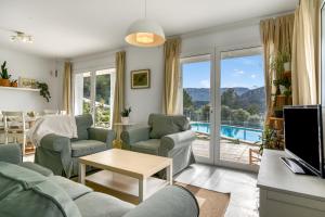 a living room with a couch and chairs and a tv at Villa Sol in Orba